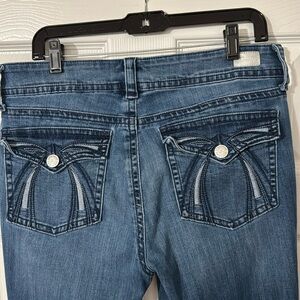 Dark blue distressed mid-rise skinny leg jeans. Size 12